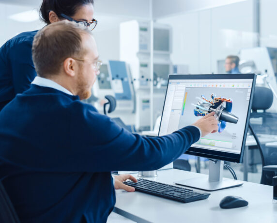 Engineer examining digital schematics on touchscreen in modern facility.