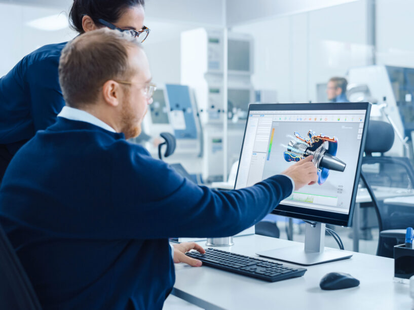 Engineer examining digital schematics on touchscreen in modern facility.